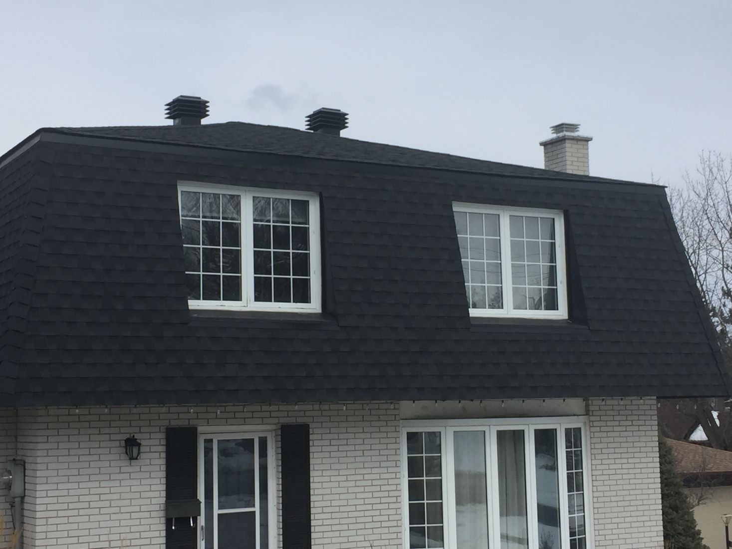 Completed dark shingles on a mansard roof